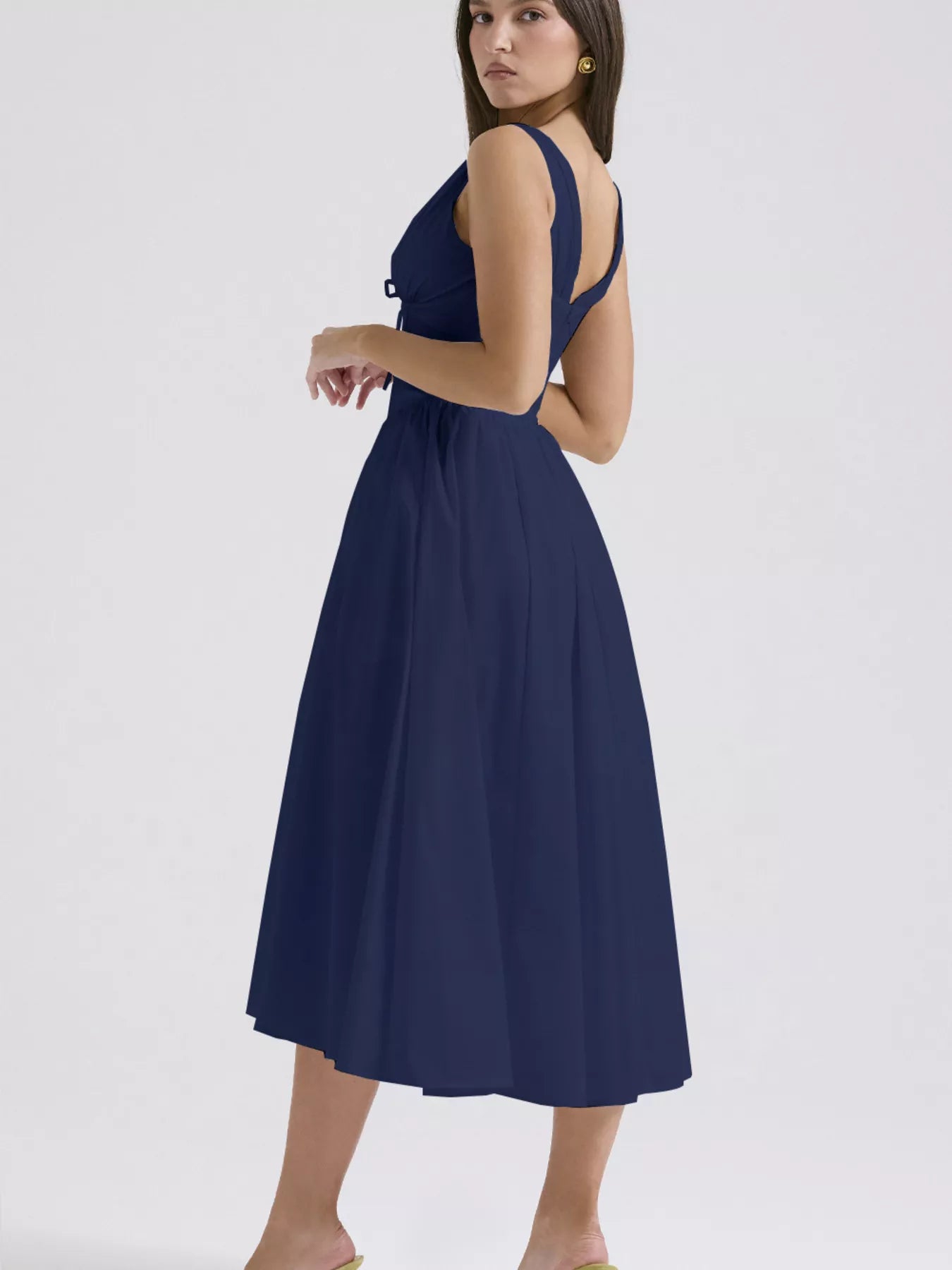 Navy blue dress with cut-out back on a white background