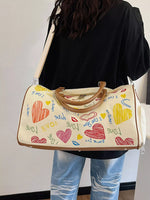 Person holding a handbag with colorful heart designs and text.