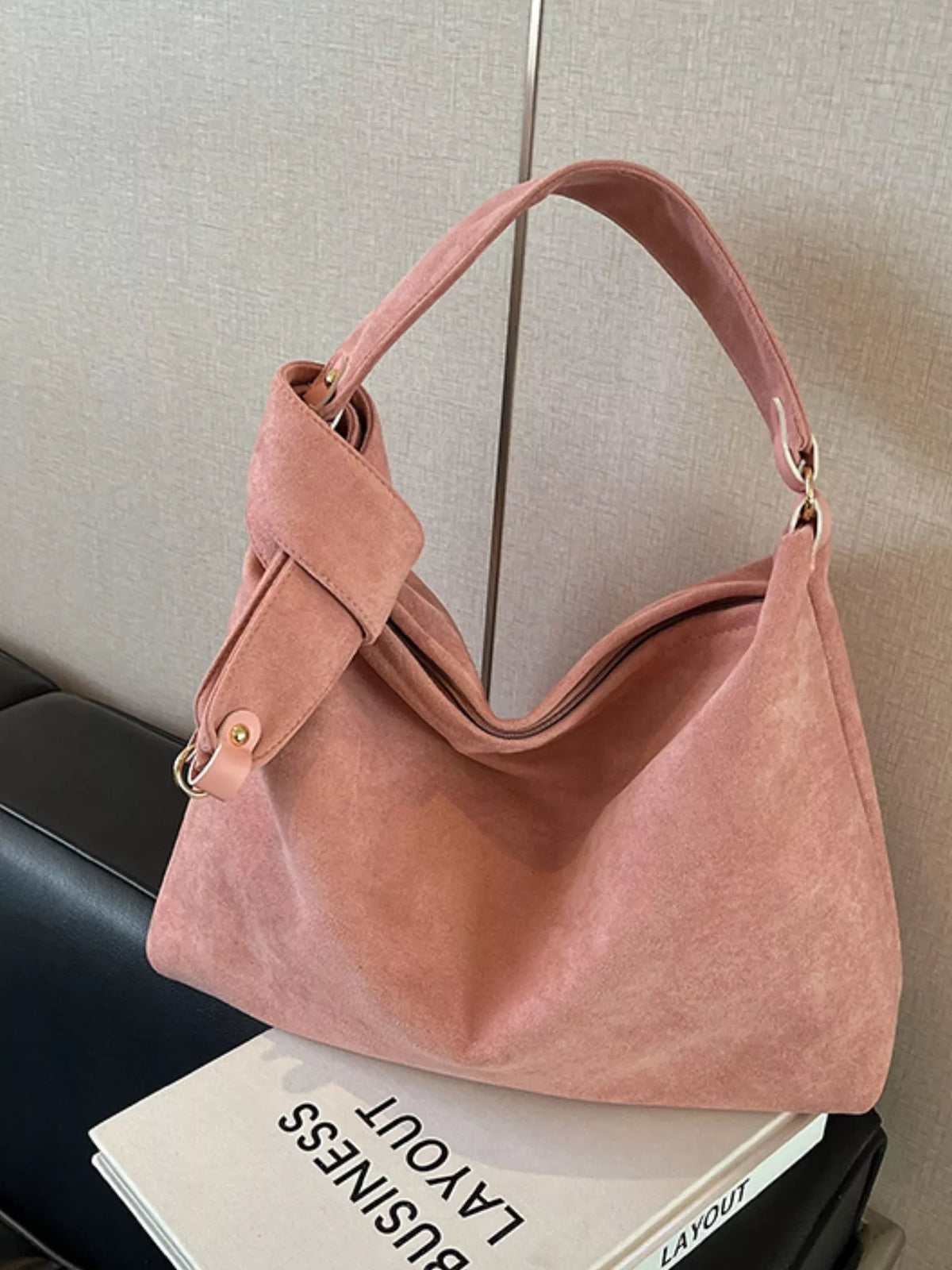 Pink handbag on a surface with a neutral background