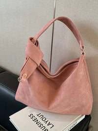 Pink handbag on a surface with a neutral background