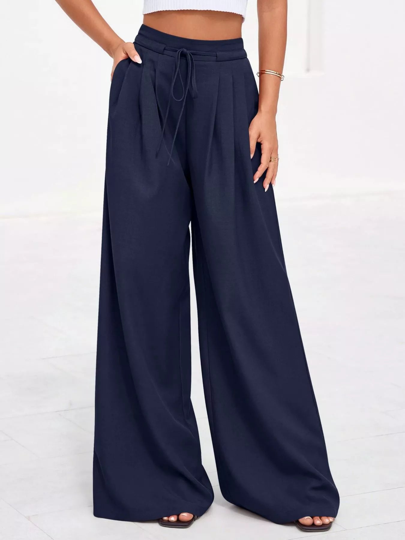 Navy wide-leg pants worn by a person on a white background