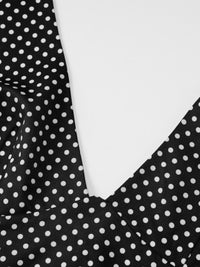 Close-up of a black polka dot fabric with a white background