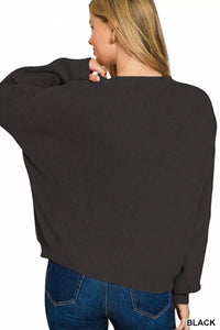 Person wearing a black sweater and blue jeans on a white background