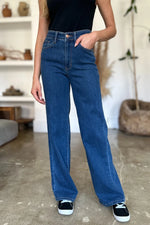 Person wearing blue jeans standing indoors with a blurred background