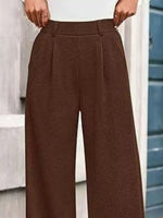 Brown wide-leg pants worn by a person, with a blurred background.