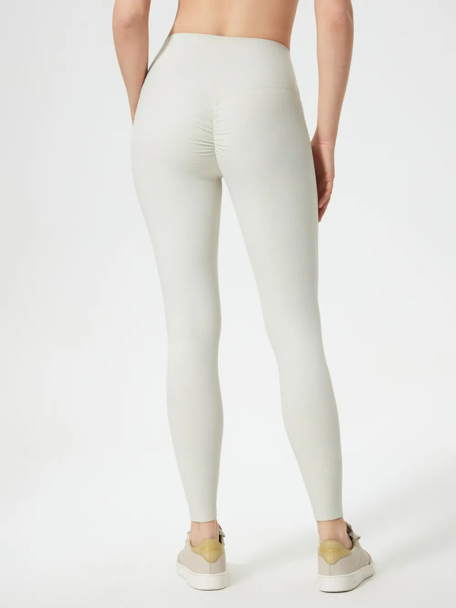 Person wearing light gray leggings on a white background