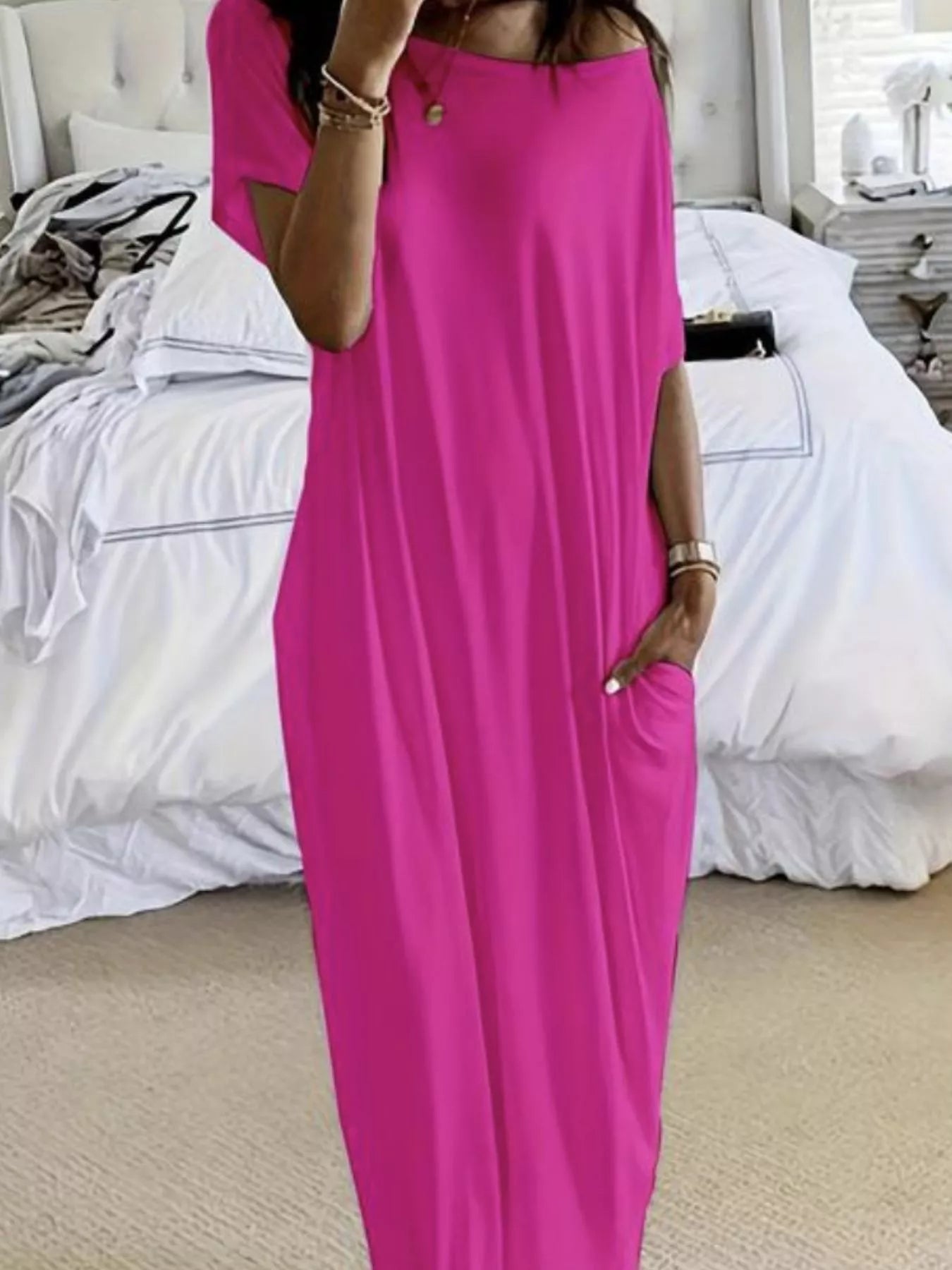 Person wearing a bright pink dress in a bedroom setting