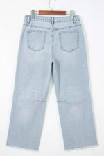 Light blue jeans hanging on a white background