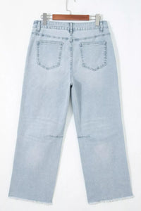 Light blue jeans hanging on a white background