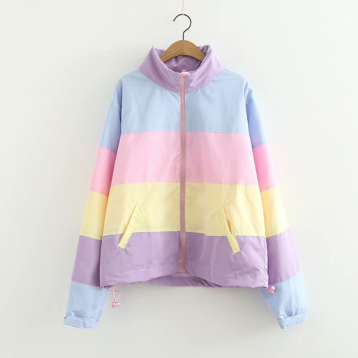 Pastel striped jacket on a hanger against a white background