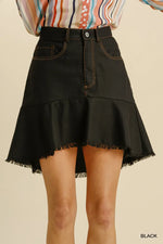 Black denim skirt worn by a person on a beige background