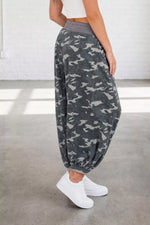 Person wearing gray camouflage pants with a white background