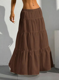 Brown tiered skirt worn by a person against a plain background