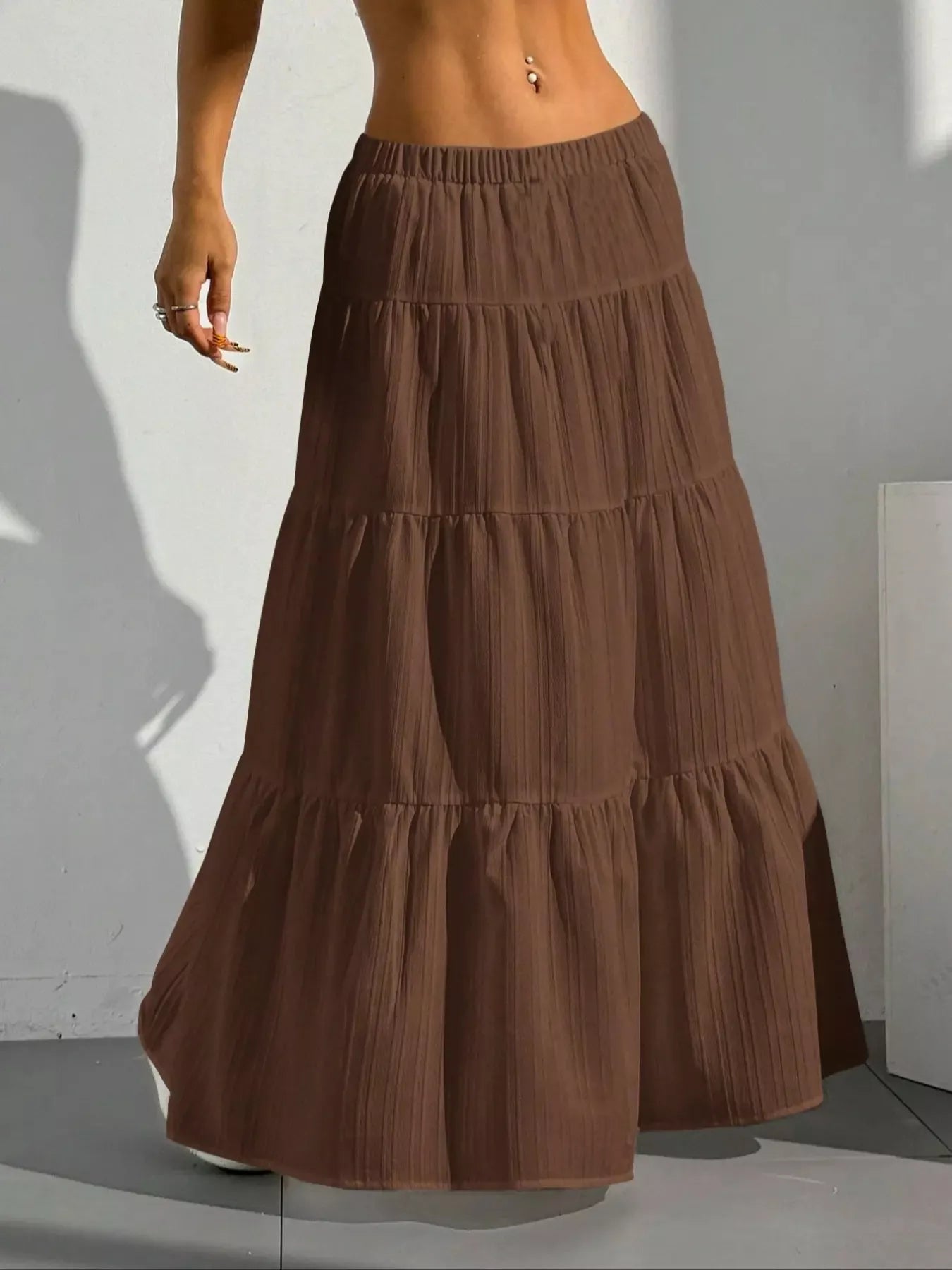 Brown tiered skirt worn by a person against a plain background