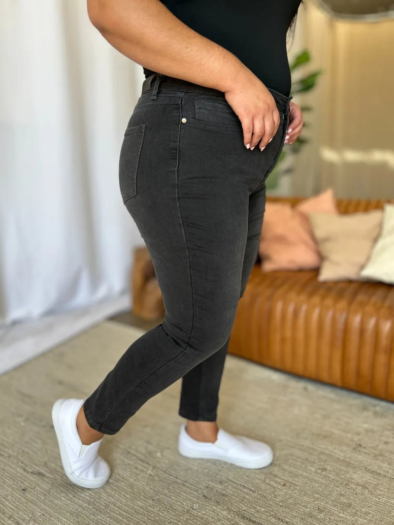 Person wearing black pants and white shoes in a living room setting