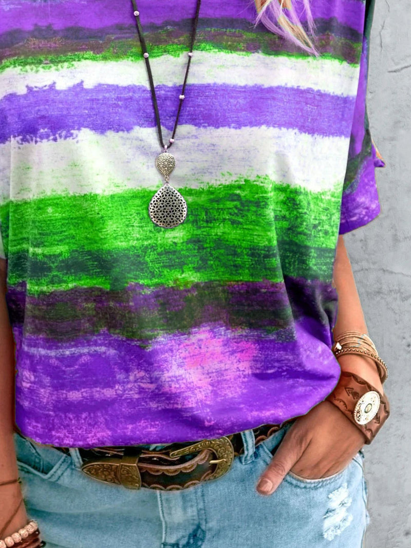 Person wearing a colorful striped shirt with a pendant necklace and bracelets.