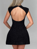 Black dress with open back on a gray background