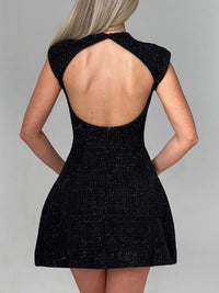 Black dress with open back on a gray background