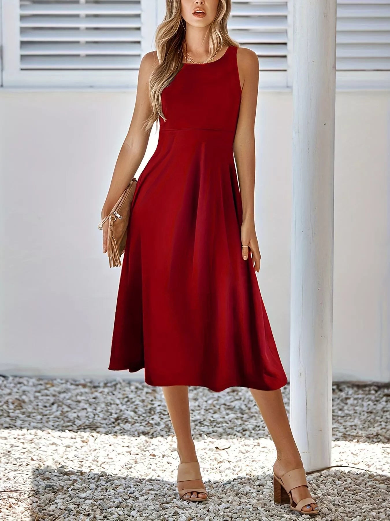 Woman wearing a red dress standing outdoors with a white building in the background