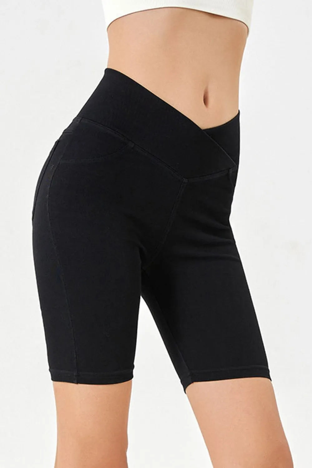 Black athletic shorts worn by a person on a white background