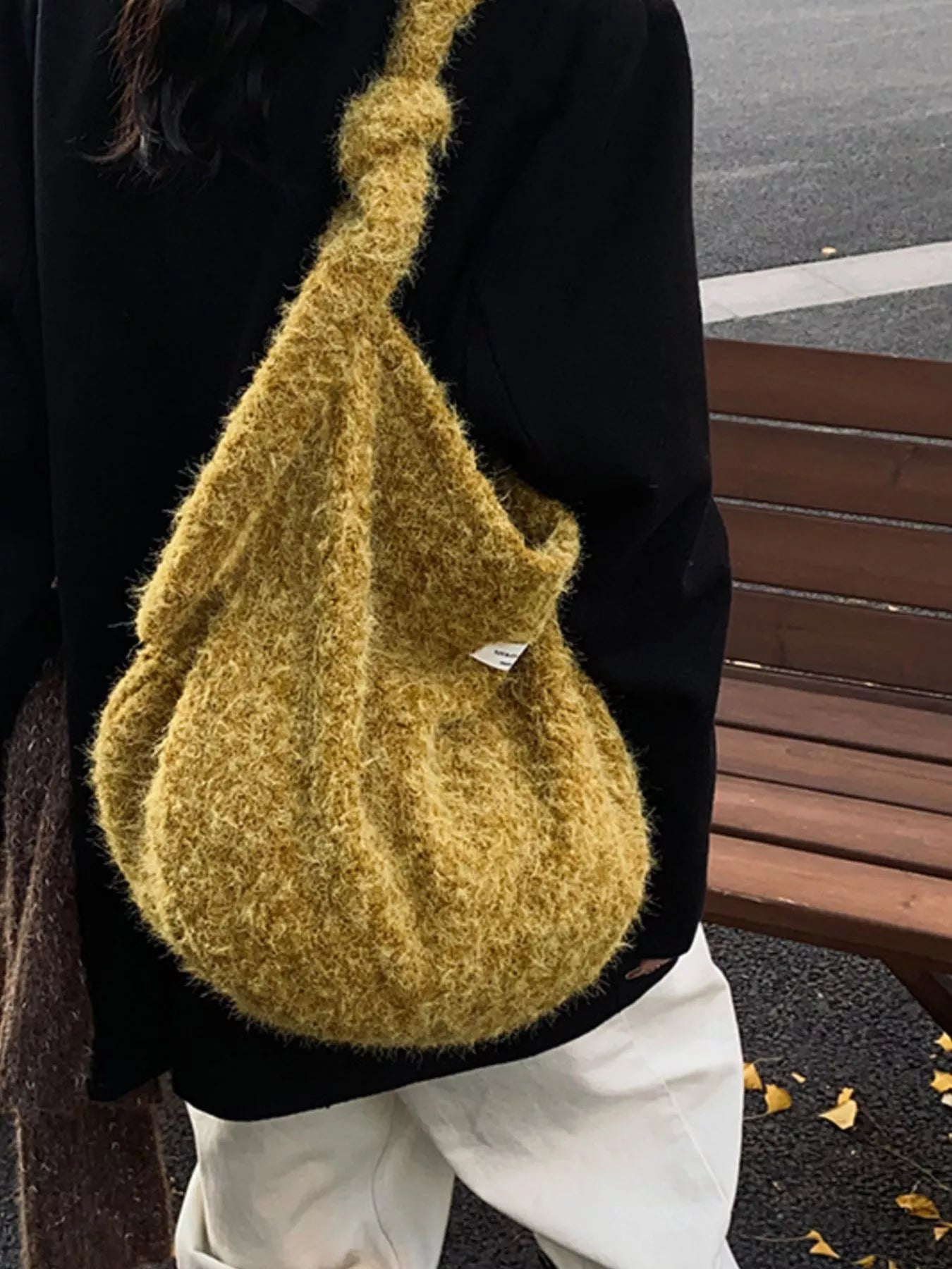 Person wearing a textured mustard yellow bag with a blurred background