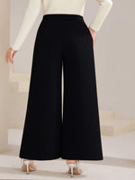 Black wide-leg pants worn by a person on a neutral background