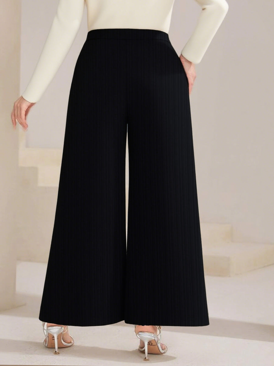 Black wide-leg pants worn by a person on a neutral background