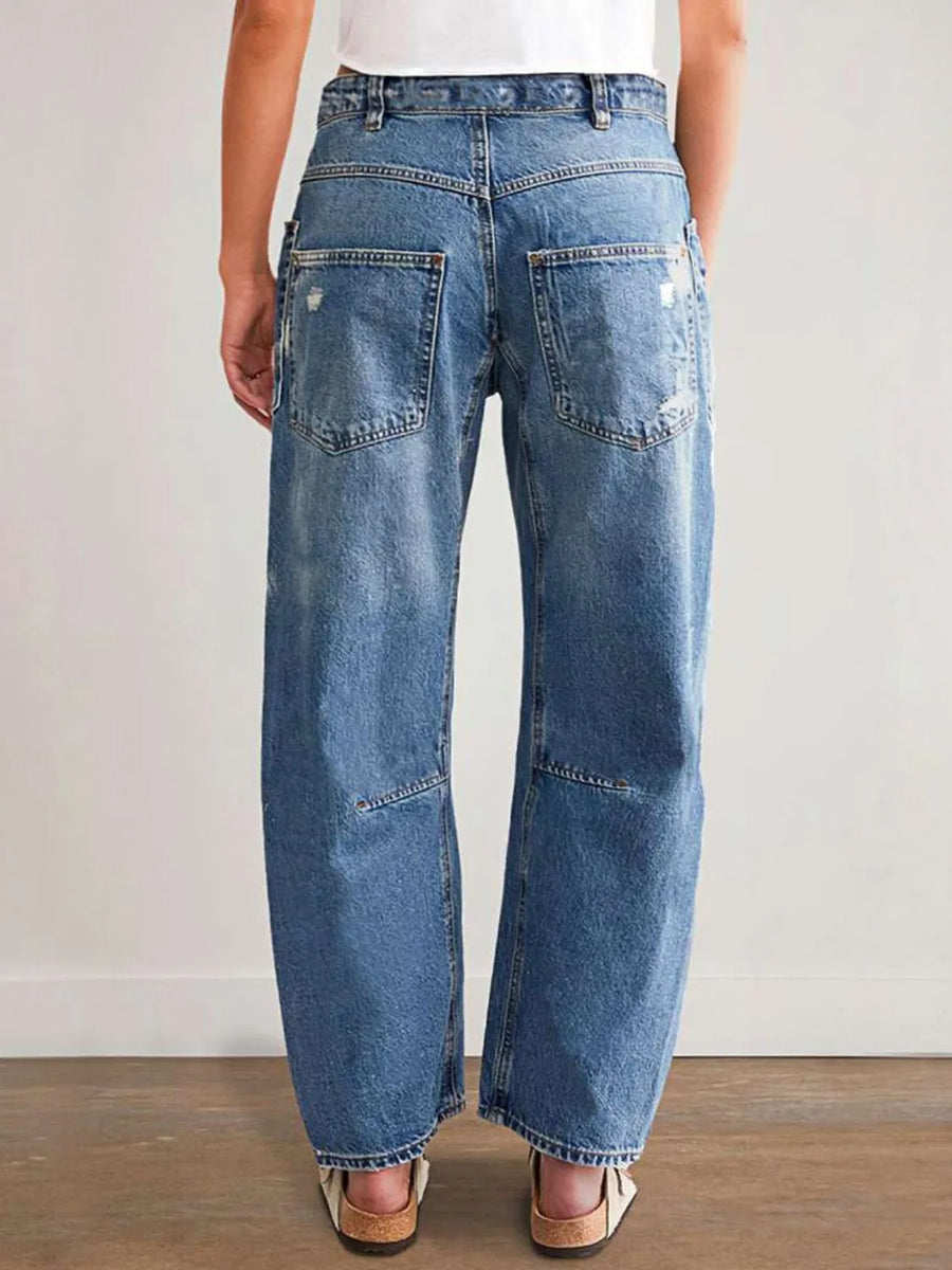Person wearing blue jeans on a plain background