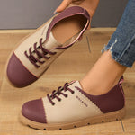 Pair of maroon and beige shoes with 'WALKING' label on a wooden floor.