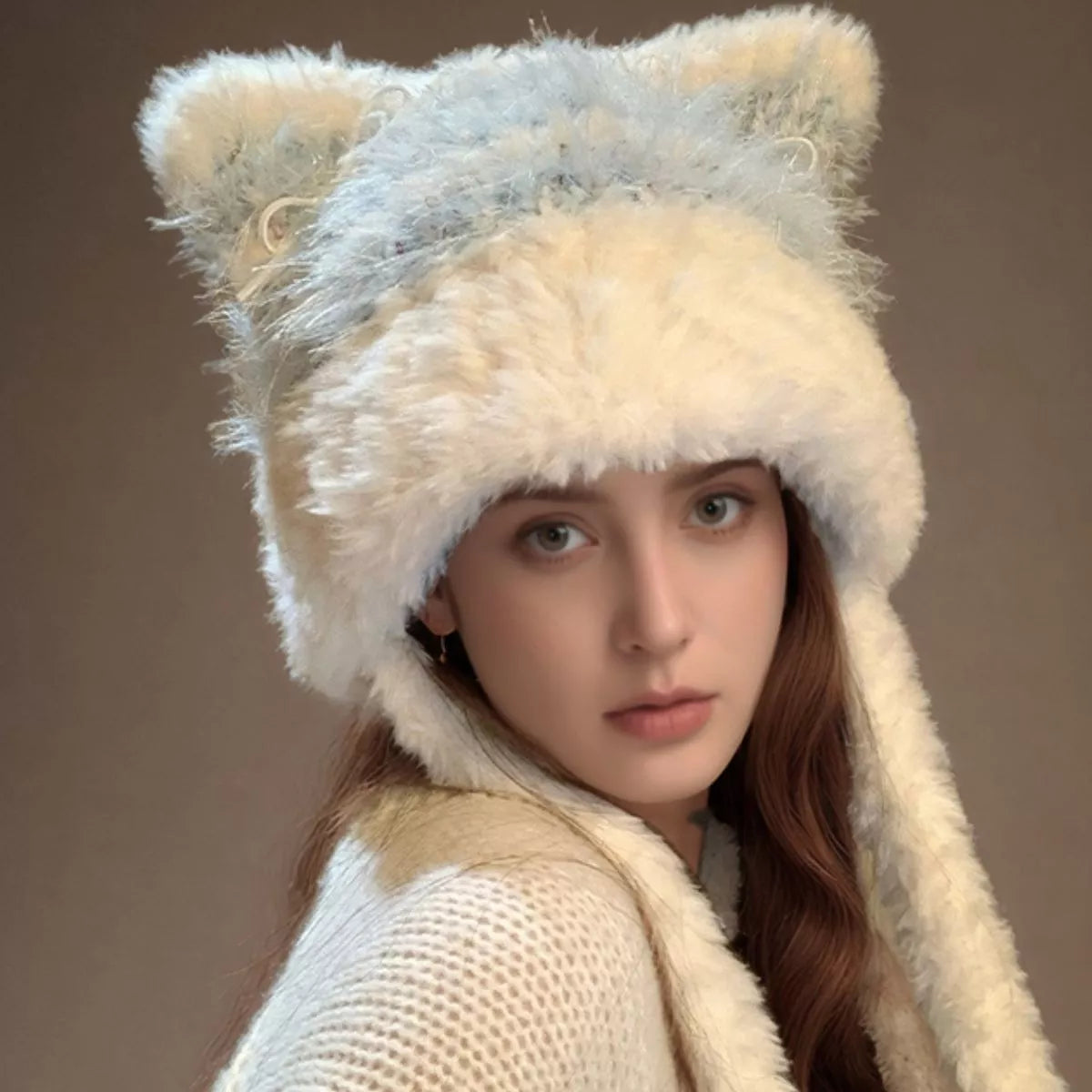 Person wearing a fluffy cat-like hat on a plain background