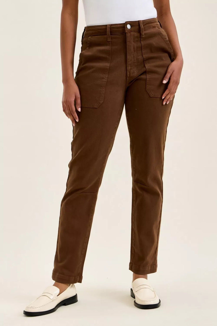 Brown pants worn by a person on a beige background