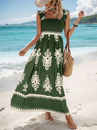Woman in a green dress with white patterns on a beach