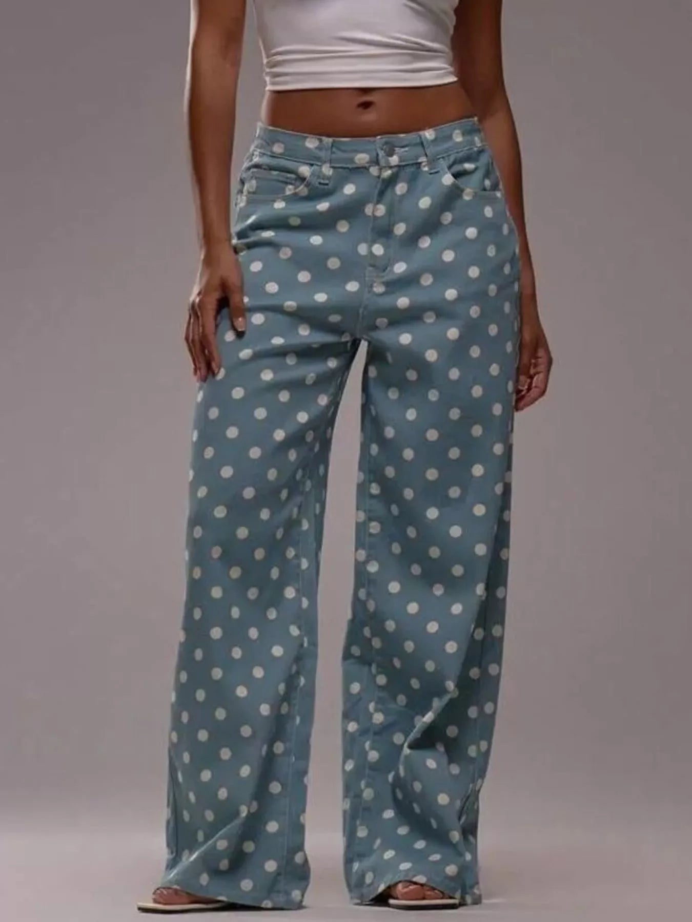 Person wearing blue polka dot pants on a plain background
