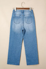 Light blue jeans on a hanger against a beige background