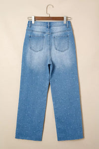Light blue jeans on a hanger against a beige background