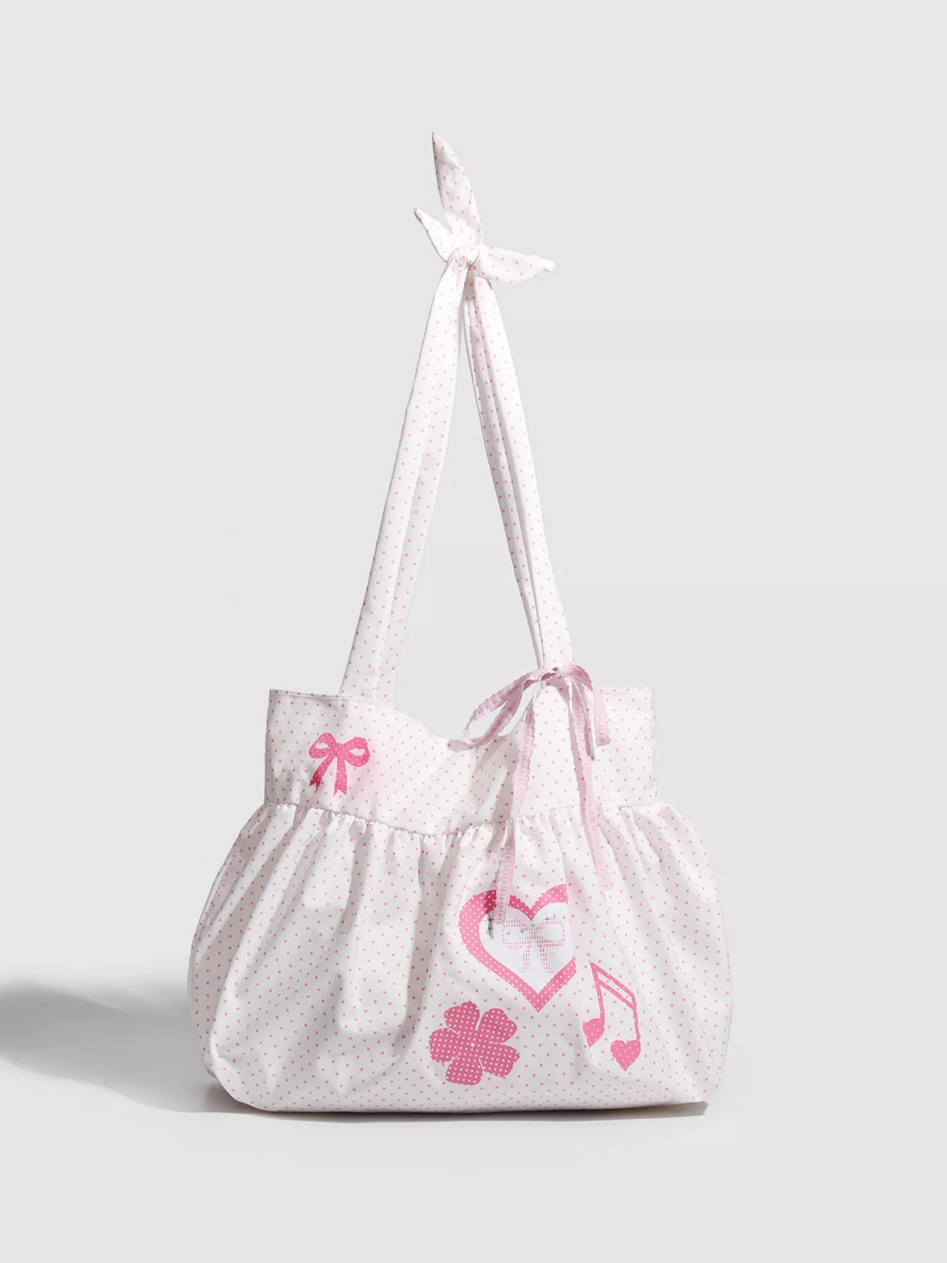 White drawstring bag with pink floral and musical note designs on a light gray background
