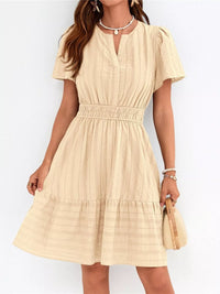 Beige dress worn by a person on a white background
