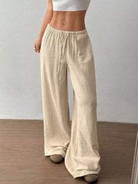 Beige wide-leg pants worn by a person on a plain background