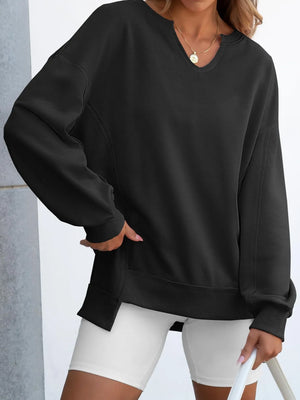 Person wearing a black sweatshirt and white shorts against a light background