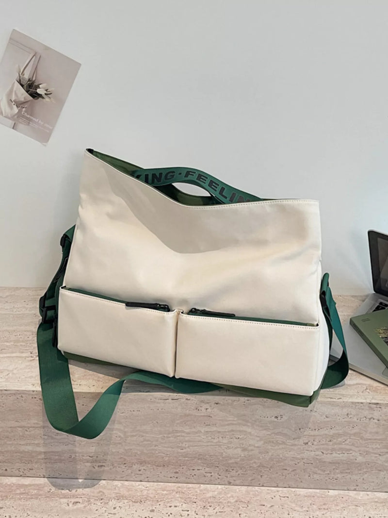 Beige tote bag with green straps on a wooden surface