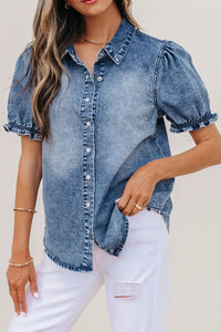 Woman wearing a denim shirt with puff sleeves against a neutral background