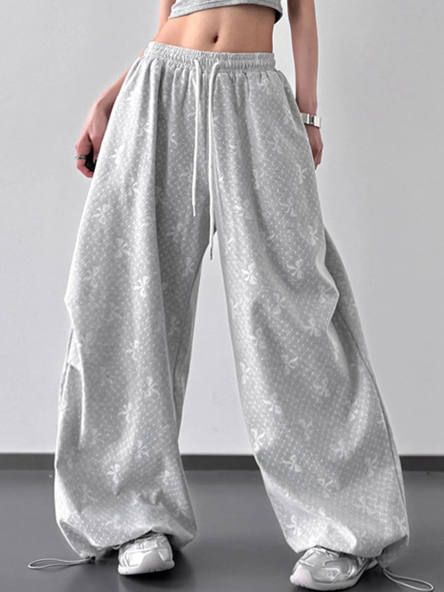 Person wearing loose-fitting gray pants on a plain background