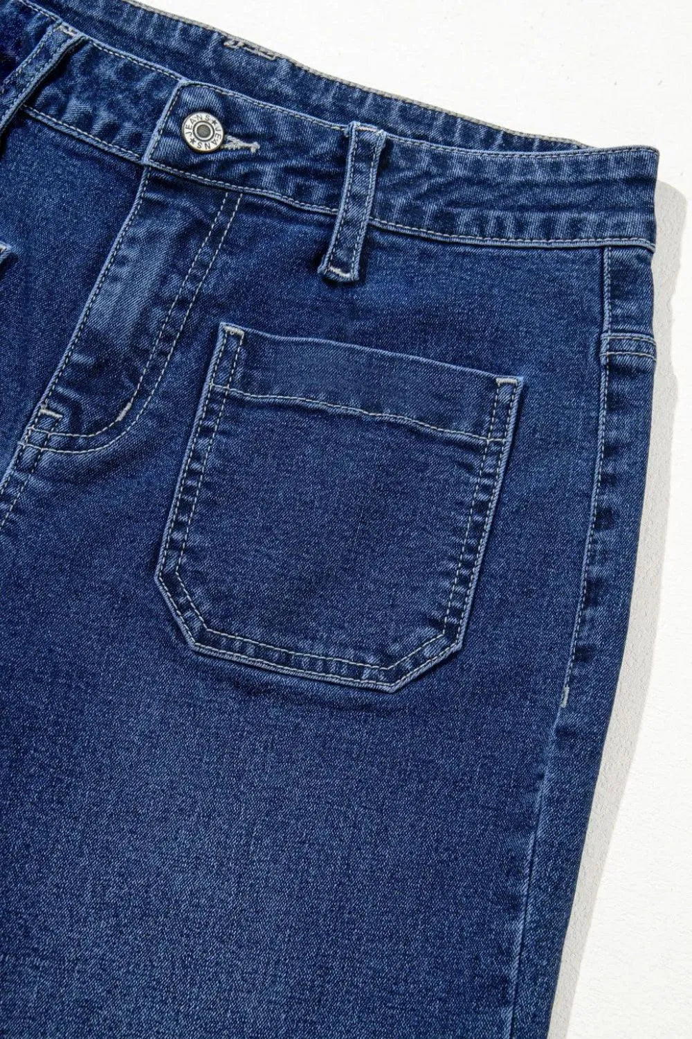 Close-up of blue denim jeans with a pocket on a white background