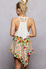 Woman wearing a white top with floral patterns on a plain background