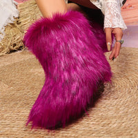 Person wearing bright pink furry boots on a woven surface