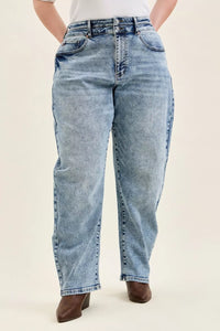 Person wearing light blue jeans on a plain background