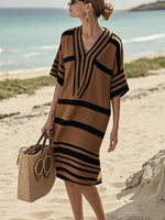 Woman on the beach in a brown and black striped dress