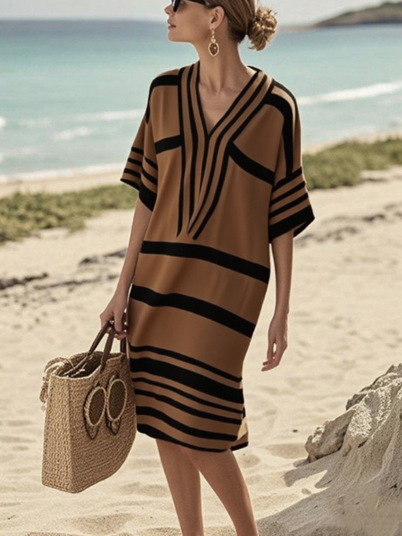 Woman on the beach in a brown and black striped dress