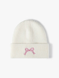 White beanie with a pink bow design on a white background