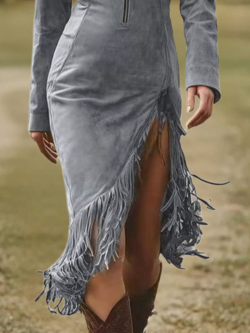 Gray suede dress with fringe details on a blurred natural background